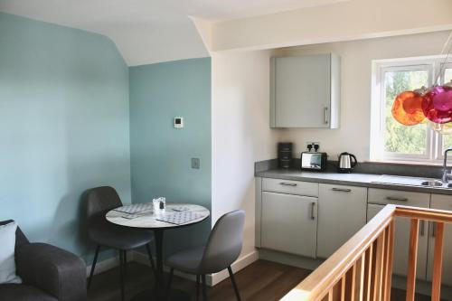 una cucina con un tavolo e sedie in una stanza di The Nestle - A Romantic Rural Retreat a Ilminster