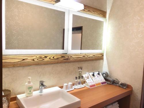 a bathroom with a sink and a mirror at KOUBOUNOYU IKONASOU in Shizuoka