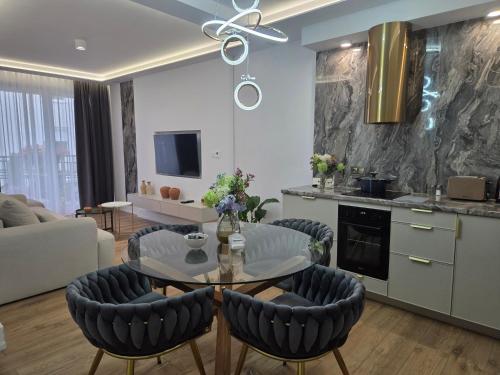 a kitchen and living room with a table and chairs at Apartament Kwiatowy DeLux in Sanok
