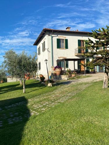a large white house on a green lawn at Casa Vacanze Bellavista in San Casciano in Val di Pesa