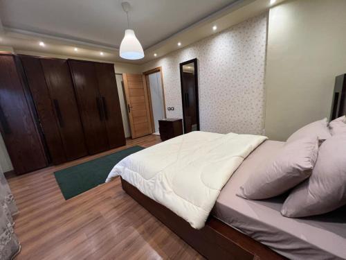 a bedroom with a large white bed in a room at New Apartment AlMohandessin near Shehab street in Cairo