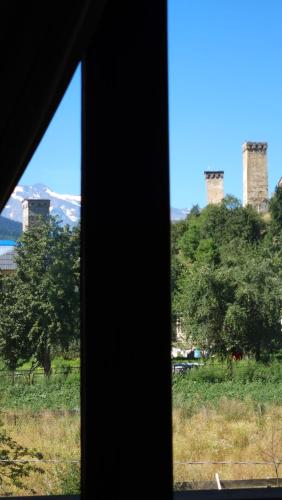 a window view of a hill with two towers at B&B Cottage in Mestia in Mestia