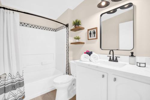 a white bathroom with a sink and a mirror at Walk to Blue Jays, Breweries, Marina & Beaches in Dunedin