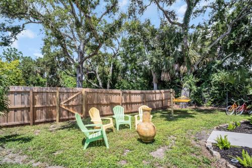 a yard with three chairs and a fence at Walk to Blue Jays, Breweries, Marina & Beaches in Dunedin