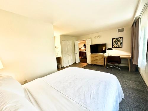 a bedroom with a white bed and a desk at Staybridge Suites East Stroudsburg - Poconos by IHG in East Stroudsburg