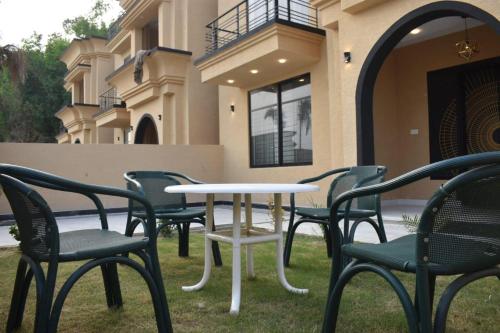 a table and chairs in front of a building at Fantastic Spanish Villas In Heart Of Mirpur Azad Kashmir Pakistan in Rachiāl