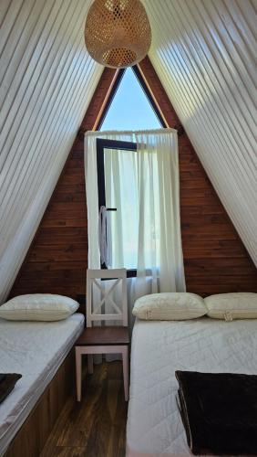 a attic bedroom with two beds and a window at B&B Cottage in Mestia in Mestia
