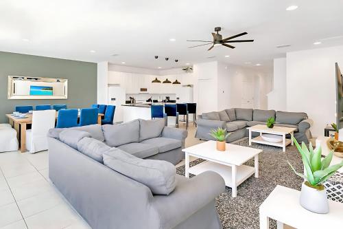 a living room with two couches and a kitchen at UPSTAY- 10BR Mansion wPrivate Pool and Games Room in Kissimmee