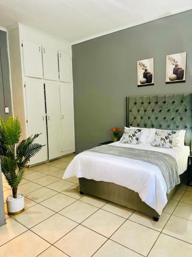 ein Schlafzimmer mit einem großen Bett und einer grünen Wand in der Unterkunft SerenityStay 37 on Zebra in Polokwane