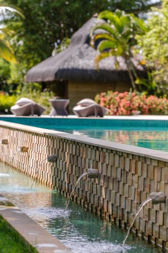 a swimming pool with water fountains in a garden at Hotel Villa Balidendê in Barra Grande