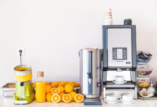 a kitchen counter with a juicer and a pile of oranges at Galini Beach Hotel in Kissamos