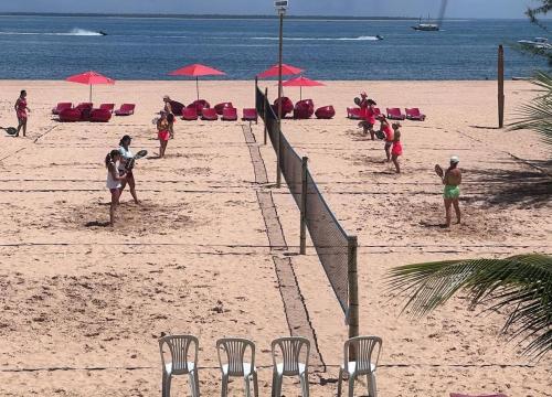 a group of people on a beach with chairs and umbrellas at Hotel Villa Balidendê in Barra Grande