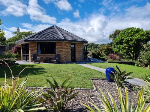a cottage in a garden with a lawn at Rosandra Retreat 1 in New Plymouth