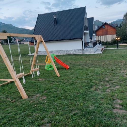 two swings in a yard with a house at BOK Holiday VILLAGE Kolasin in Kolašin