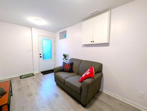 a living room with a couch and a red pillow at Bright & New 2 Beds Near Subway in Toronto