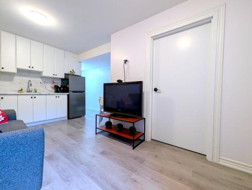 a living room with a television and a kitchen at Bright & New 2 Beds Near Subway in Toronto