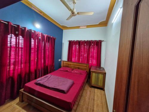a bedroom with a red bed and red curtains at Coorg Coffee Tales in Suntikoppa