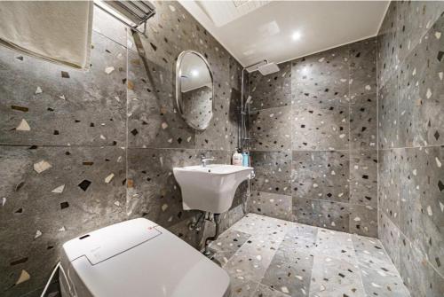 a bathroom with a white toilet and a sink at 12번길stay 