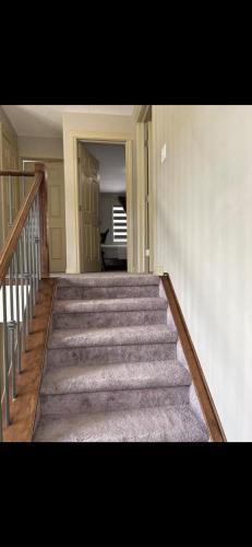 a stairway in a home with a stair case at Coastal Comforts Villa in Airdrie