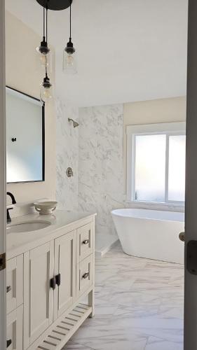 a bathroom with a tub and a sink and a mirror at Sandy Pacific Hideaway 1 in Florence