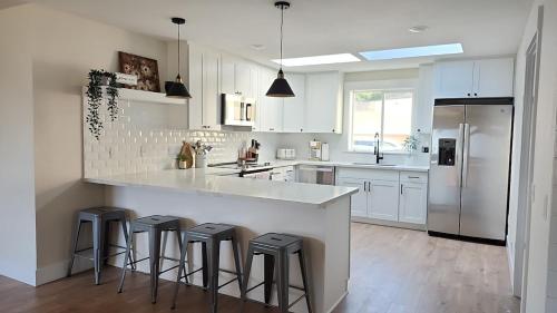 a white kitchen with a large island with bar stools at Sandy Pacific Hideaway 1 in Florence