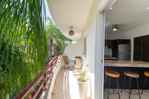 a balcony with a table and chairs and a kitchen at Margaritas Condo in Downtown of Playa in Playa del Carmen