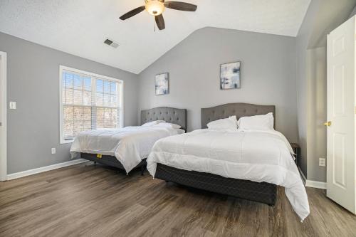 オーステルにあるCozy home in Austellのベッド2台と天井ファン付きの寝室