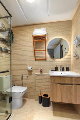 a bathroom with a toilet sink and a mirror at Luxury & elegant Apartment, Parc Serenity in Mohammedia