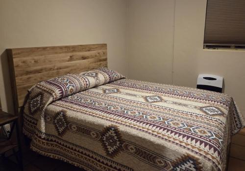 a bed with a wooden headboard in a bedroom at The Ranch House Inn in Bowie