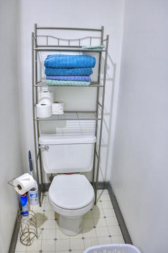 a bathroom with a toilet and towels on a shelf at K3 2nd Floor Studio Stay, Eat, Drink, MTU, Keweenaw 