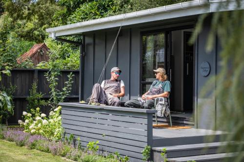 two people sitting on the porch of a house at The Quarters in Turangi