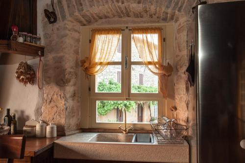 eine Küche mit einem Waschbecken und einem Fenster in der Unterkunft Casa Vecia in Brtonigla