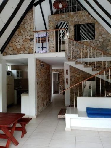 a living room with a spiral staircase in a house at Melgar Casa Piedras del Agua in Estación El Salto