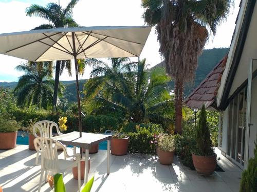 a patio with an umbrella and a table and chairs at Melgar Casa Piedras del Agua in Estación El Salto