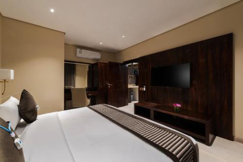 a hotel room with a bed and a flat screen tv at فندق فيو الشاطي - Beach View Hotel in Dammam
