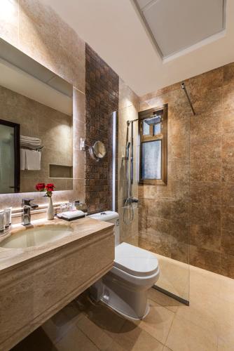 a bathroom with a toilet and a sink and a shower at فندق فيو الشاطي - Beach View Hotel in Dammam