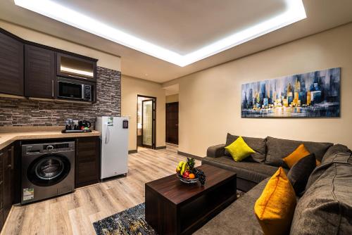 a living room with a couch and a kitchen at فندق فيو الشاطي - Beach View Hotel in Dammam