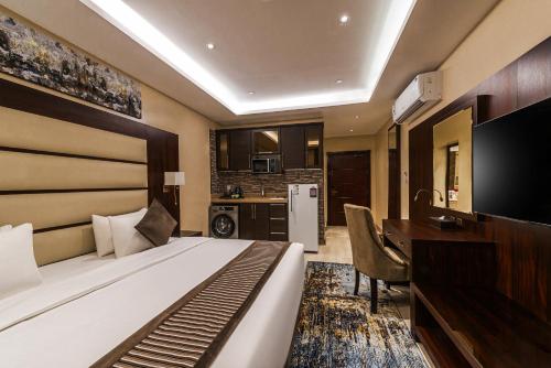 a hotel room with a bed and a desk and a kitchen at فندق فيو الشاطي - Beach View Hotel in Dammam