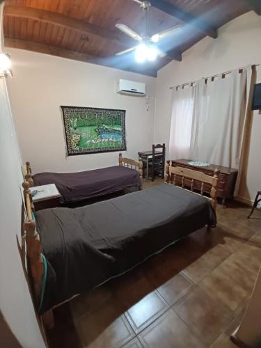 a bedroom with two beds and a table in it at PUNTA ALTA Encanto in Punta Alta