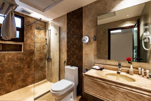 a bathroom with a toilet and a sink and a shower at فندق فيو الشاطي - Beach View Hotel in Dammam