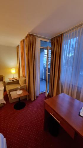 a hotel room with a bedroom with a bed and a desk at Hotel am Rosenpark in Aachen
