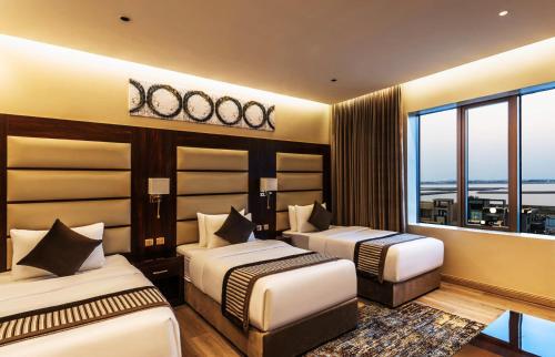 a hotel room with two beds and a large window at فندق فيو الشاطي - Beach View Hotel in Dammam