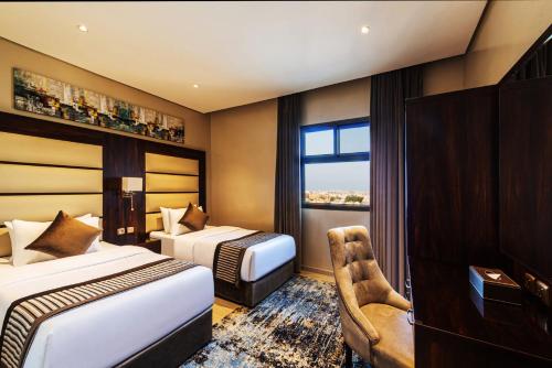 a hotel room with two beds and a window at فندق فيو الشاطي - Beach View Hotel in Dammam