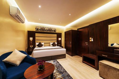 a hotel room with a bed and a blue couch at فندق فيو الشاطي - Beach View Hotel in Dammam