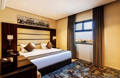 a hotel room with a large bed and a window at فندق فيو الشاطي - Beach View Hotel in Dammam