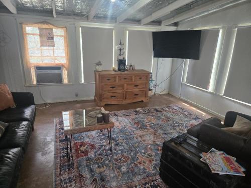 a living room with a couch and a table at Bigfoots Bungalow in Bandera