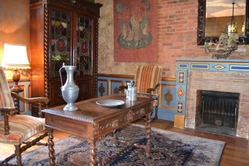 a living room with a table and a fireplace at Château de Peufeilhoux in Vallon-en-Sully