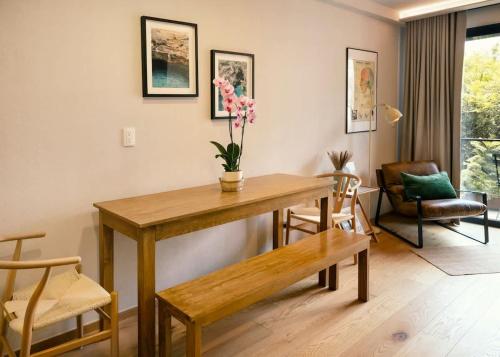 a living room with a wooden table and a bench at Roma Norte Retreat - CDMX Vibes in Mexico City