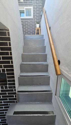a set of stairs with a wooden hand rail at Banwoldang Stn 3min, 2F 4pm & 3F 8pm Check-in, Table for 6, Hotel bedding, Luggage Storage in Daegu