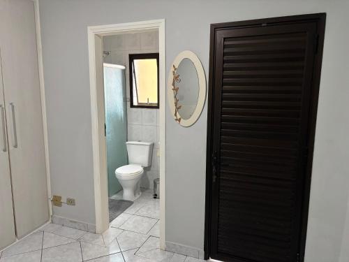 ein Badezimmer mit Toilette und schwarzer Tür in der Unterkunft Apto 2 dorm - Requinte na Praia Grande - SP in Praia Grande